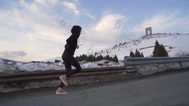 太阳落山时，精力充沛的专业女赛跑<strong>选手</strong>在雪山上练习